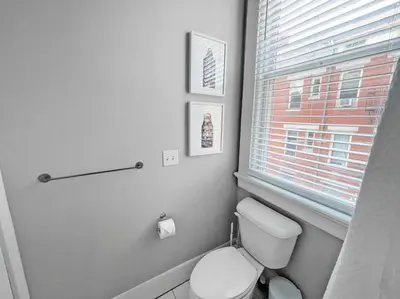 a bathroom with a white toilet and a window at Quiet 1-Bedroom Loft near Entertainment District in Cincinnati