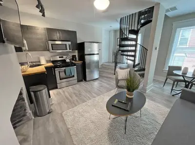 a living room with a couch and a table in a kitchen at Quiet 1-Bedroom Loft near Entertainment District in Cincinnati