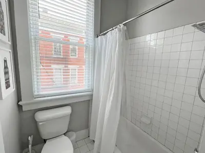 a bathroom with a toilet and a window and a shower at Quiet 1-Bedroom Loft near Entertainment District in Cincinnati