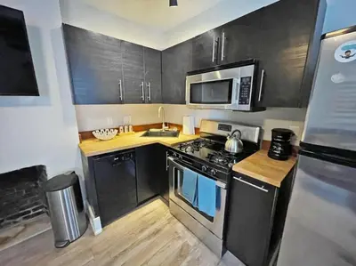 a small kitchen with a stove and a microwave at Quiet 1-Bedroom Loft near Entertainment District in Cincinnati