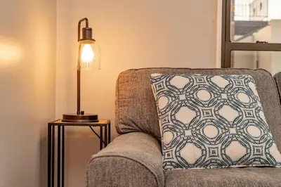 a lamp sitting next to a couch with a pillow at Mt Adams 1BR Great Location Steps from Monastery in Cincinnati