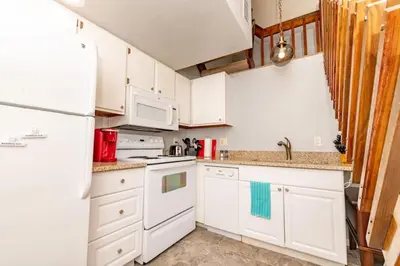 a kitchen with white cabinets and a white refrigerator at Mt Adams 1BR Great Location Steps from Monastery in Cincinnati