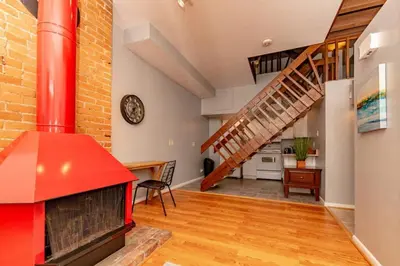 a living room with a red stove and a staircase at Mt Adams 1BR Great Location Steps from Monastery in Cincinnati