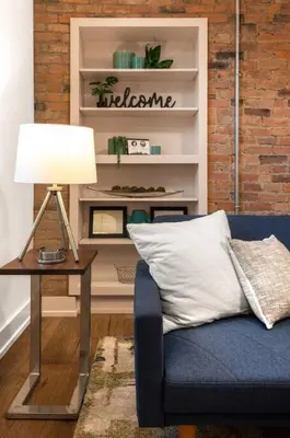 a living room with a blue couch and a table with a lamp at WALK TO ALL in Over The Rhine Cincinnati in Cincinnati