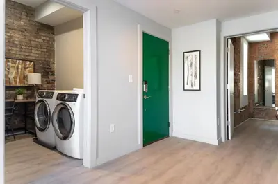 a laundry room with a washer and a green door at TRUTH Old world charm meets New world love in Cincinnati