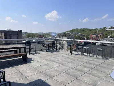 a patio with tables and chairs on a roof at TRUTH Old world charm meets New world love in Cincinnati