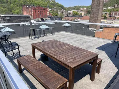 a wooden table and benches on a roof at TRUTH Old world charm meets New world love in Cincinnati