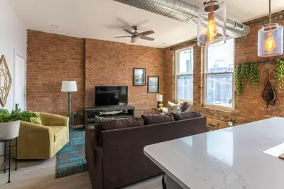 an industrial living room with a brick wall at TRUTH Old world charm meets New world love in Cincinnati