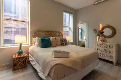 a bedroom with a large bed and two windows at ZANGO Explore OTR and Downtown from a Renovated Condo in Cincinnati