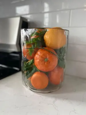 a glass jar filled with oranges on a counter at ZANGO Explore OTR and Downtown from a Renovated Condo in Cincinnati