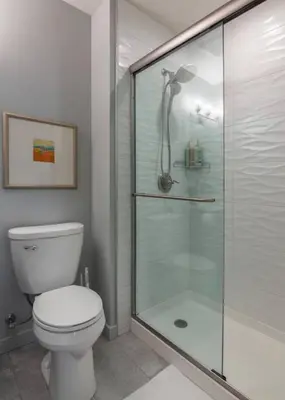a bathroom with a toilet and a glass shower at ZANGO Explore OTR and Downtown from a Renovated Condo in Cincinnati