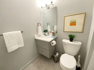 a bathroom with a toilet and a sink and a mirror at ZANGO Explore OTR and Downtown from a Renovated Condo in Cincinnati