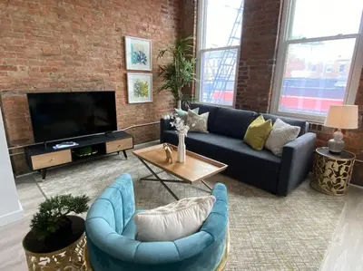 a living room with a couch and a tv at SWIZZLE Explore OTR and Downtown from Rhinegeist in Cincinnati