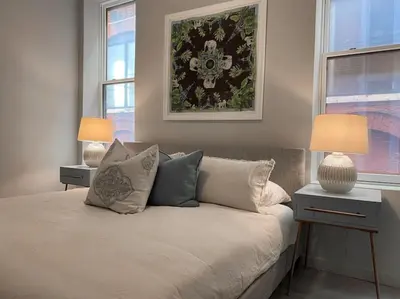a bedroom with a bed with pillows and two lamps at SWIZZLE Explore OTR and Downtown from Rhinegeist in Cincinnati