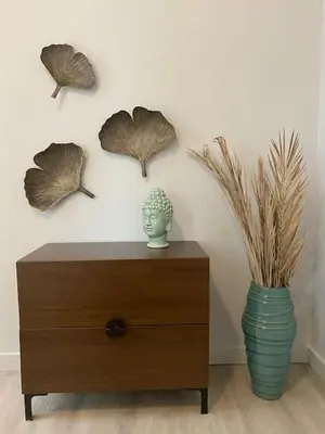 a wooden dresser with a vase and some leaves on the wall at SWIZZLE Explore OTR and Downtown from Rhinegeist in Cincinnati