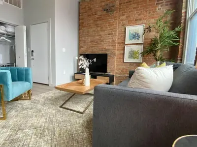 a living room with a couch and a fireplace at SWIZZLE Explore OTR and Downtown from Rhinegeist in Cincinnati
