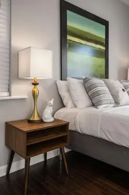 a bedroom with a bed and a table with a lamp at Stunning 2BR Apartment Near Downtown in Cincinnati
