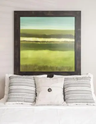 a painting above a bed with white pillows at Stunning 2BR Apartment Near Downtown in Cincinnati