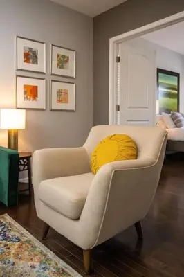 a living room with a yellow pillow on a chair at Stunning 2BR Apartment Near Downtown in Cincinnati