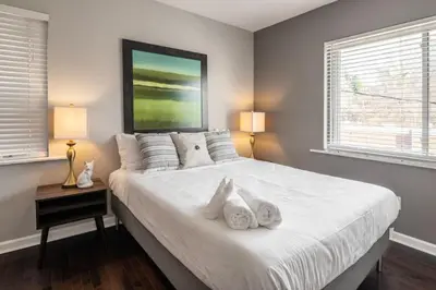 a bedroom with a large white bed with two lamps at Stunning 2BR Apartment Near Downtown in Cincinnati