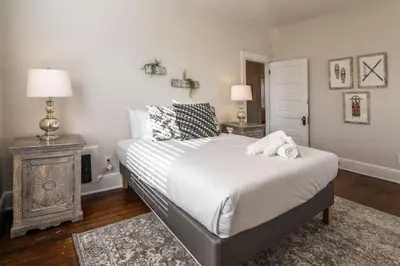 a bedroom with a bed and two night stands and two lamps at Deluxe 6 Bedroom 3 Min to Downtown w 2-car Driveway in Cincinnati