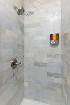 a bathroom with a shower with white tiles at Deluxe 6 Bedroom 3 Min to Downtown w 2-car Driveway in Cincinnati