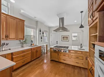 a kitchen with wooden cabinets and a stove top oven at Deluxe 6 Bedroom 3 Min to Downtown w 2-car Driveway in Cincinnati