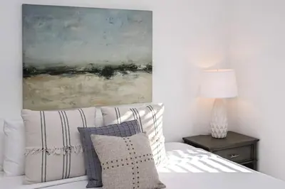 a bedroom with a bed with a painting on the wall at Adorable MtAdams 2BR near it all in Cincinnati