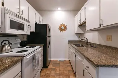 a kitchen with white cabinets and a stove at Adorable MtAdams 2BR near it all in Cincinnati