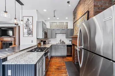a kitchen with stainless steel appliances and a brick wall at Loft in the heart of Over-The-Rhine in Cincinnati