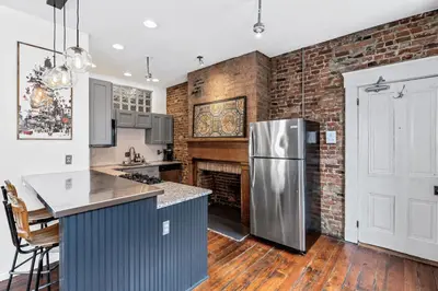 a kitchen with a brick wall and a stainless steel refrigerator at Loft in the heart of Over-The-Rhine in Cincinnati