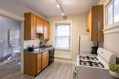 a kitchen with wooden cabinets and a white refrigerator at Hyde Park Comfort with Office Near Everything in Cincinnati