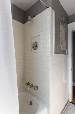 a bathroom with a tub and a white tile shower at Hyde Park Comfort Near Rookwood in Cincinnati