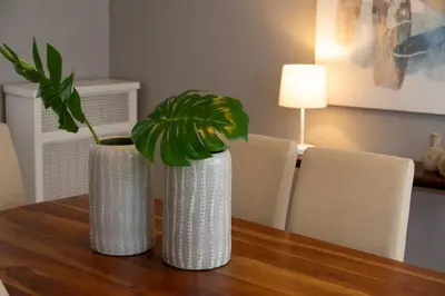 two white vases sitting on a wooden table with a plant at Hyde Park Comfort Near Rookwood in Cincinnati