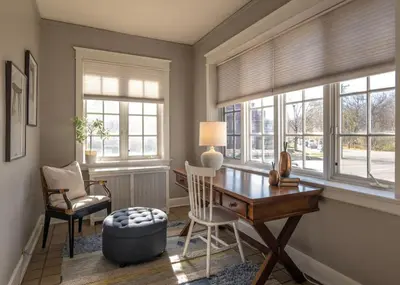 a home office with a desk and chairs and windows at Hyde Park Comfort Near Rookwood in Cincinnati