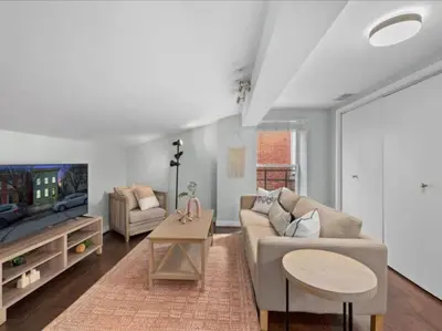 a living room with a couch and a tv at Studio steps to Soccer and OTR and Downtown in Cincinnati