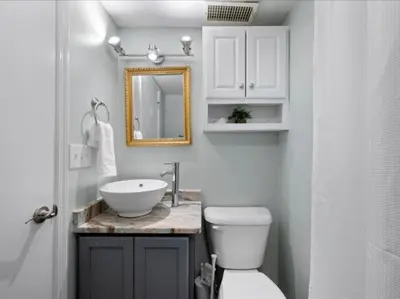 a bathroom with a sink and a toilet and a mirror at Studio steps to Soccer and OTR and Downtown in Cincinnati