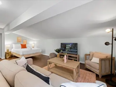 a living room with a couch and a tv at Studio steps to Soccer and OTR and Downtown in Cincinnati