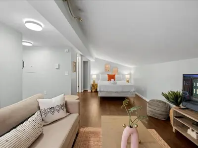 a living room with a couch and a bed at Studio steps to Soccer and OTR and Downtown in Cincinnati