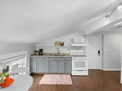 a kitchen with white appliances and a table in a room at Studio steps to Soccer and OTR and Downtown in Cincinnati