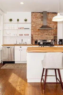 a kitchen with white cabinets and a brick wall at Walk to Rhinegeist, Findlay Market, FREE Streetcar in Cincinnati