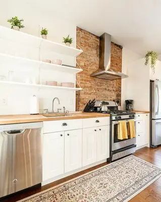 a kitchen with white cabinets and a brick wall at Walk to Rhinegeist, Findlay Market, FREE Streetcar in Cincinnati