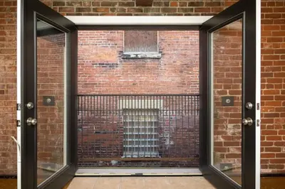 an open door to a brick wall with a window at Spacious Retreat w Private Roof Deck Walkable to ALL in Cincinnati