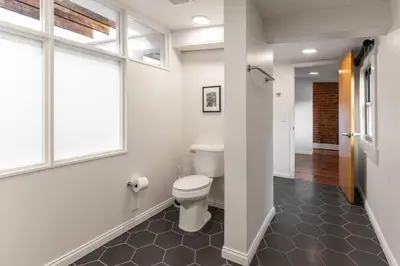 a bathroom with a toilet and a window at Spacious Retreat w Private Roof Deck Walkable to ALL in Cincinnati
