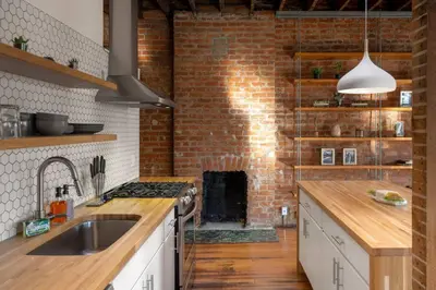 a kitchen with a brick wall and a stove at Spacious Retreat w Private Roof Deck Walkable to ALL in Cincinnati