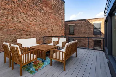 a patio with a wooden table and chairs on a balcony at Deluxe 3BR Loft Walkable to Everything Downtown in Cincinnati
