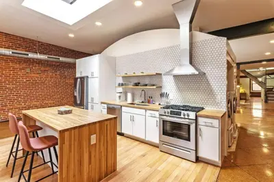 a kitchen with white appliances and a brick wall at Deluxe 3BR Loft Walkable to Everything Downtown in Cincinnati