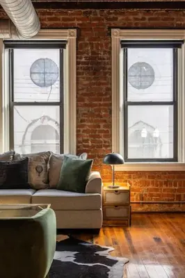 a living room with a couch and two windows at Stunning Loft in the heart of OTR in Cincinnati