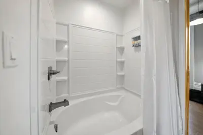 a white bathroom with a shower and a tub at City Escape 2BR Steps to TQL near OTR and Downtown in Cincinnati