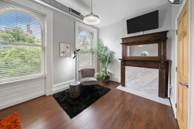 a living room with a fireplace and a flat screen tv at City Escape 2BR Steps to TQL near OTR and Downtown in Cincinnati